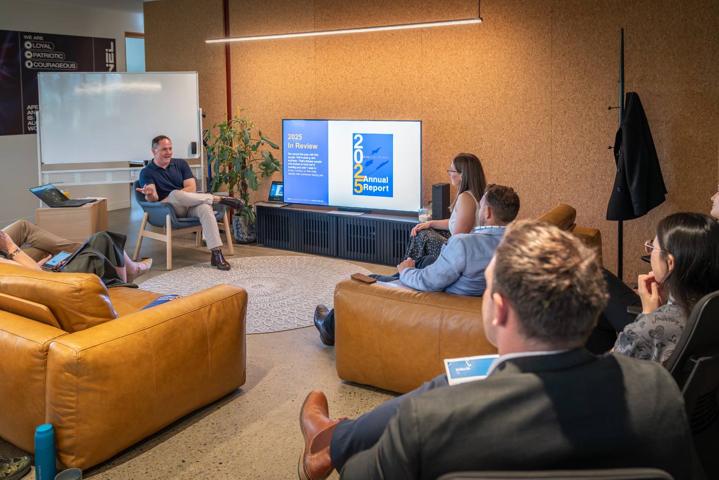 Team gathered on couches for an all-hands presentation